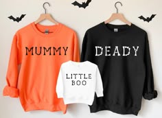 two sweatshirts that say, mommy and baby are hanging on a wall with bats