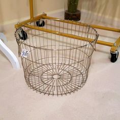 a wire basket sitting on the floor next to a chair