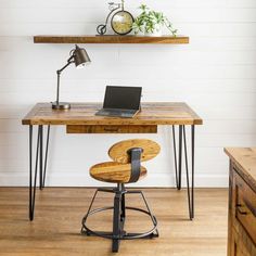 a wooden desk with a laptop on it and some shelves above the desk in front of it