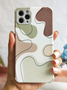 a woman is holding up her phone case with an abstract design on the front and back