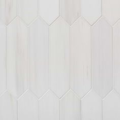 white hexagonal tiles are arranged in rows on the wall, with one corner missing