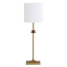 a lamp that has a white shade on it and gold metal base with a light bulb