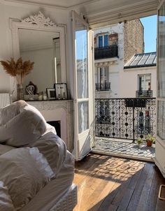 an open door leading to a balcony with a bed and mirror on it's side