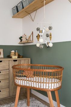 a baby's crib in the corner of a room with green and white walls