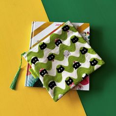 three small pouches with black cats on green, white and yellow designs sitting next to each other