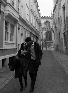 a man and woman walking down an alley way