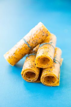 three rolled up food items on a blue surface