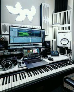 an electronic keyboard sitting on top of a desk next to a monitor and sound equipment