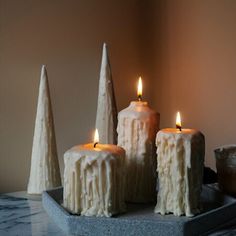 three white candles sitting on top of a table