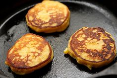 three pancakes sitting on top of a black pan