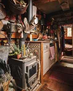 an old fashioned stove in the middle of a room filled with pots and pans