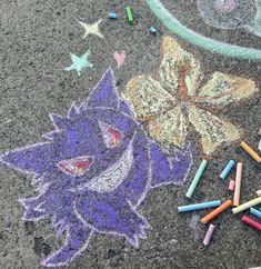 some crayons are laying on the ground next to a drawing of a cat