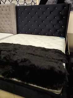 a bed that has been made with black sheepskin on the top and bottom part