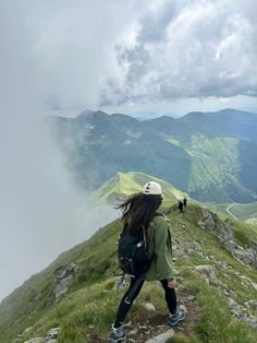 a woman hiking up the side of a mountain with her back to the camera,