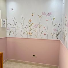 a bathroom with pink walls and flowers painted on the wall