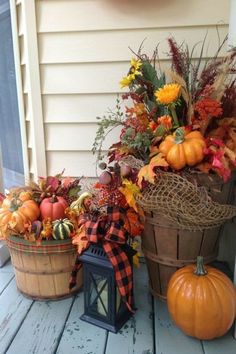 two baskets filled with pumpkins and other autumn decorations on the front door porch,