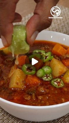 a person is dipping some food into a bowl