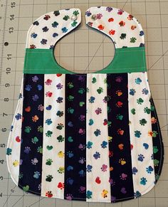 "This colorful handmade 100% cotton baby bib is quilted using a variety of scrap fabric I had left over from previous projects. The 3-layer bib is cute, soft, and REVERSIBLE!  Each of my quilted bibs are unique; no two are alike.  The bib front is made of a variety of cotton fabrics. The bib back is solid navy blue cotton. The middle layer is white cotton flannel. The bib is finished with a simple, straight topstitch, and fastens with a pearl snap. It measures approximately 10\" x 13 inches. The neck opening is approximately 12 inches in circumference when the bib is snapped. The length from the chin drop to the bib bottom is 8 inches. The bib was handmade with love and care by ME in my pet-free and smoke-free home. Proudly made in Livermore, CA.   Care Instructions: Machine wash gentle cy Cute Cotton Bib For Playtime, Multicolor Cotton Bib, Machine Washable, Cute Handmade Cotton Bib, Handmade White Cotton Patterns, Multicolor Washable Bib For Playtime, Blue Cotton Bib For Playtime, Cute Multicolor Machine Washable Bib, Playful Blue Cotton Bib, Handmade Multicolor Cotton Patterns