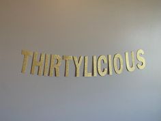 the word thirtylicious spelled out in gold foil