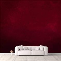 a white couch sitting in front of a red wall