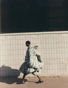 a woman walking down the street in a puffy coat