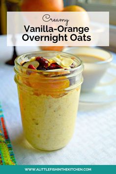 an orange overnight oats in a glass jar on a white tablecloth with fruit