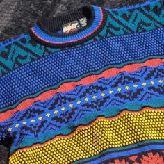 Vintage Pullover Knit Sweater With Textured Geometric Pattern In Bright Primary Colors On Black Background By Lightning Bolt. Tagged Size Medium. Good Vintage Condition With Minor Pilling. See Photos For Details. Please Comment Below With Any Questions. *Many Of Our Items Come From Estate Sales Or Other Sources, Which Means We Do Not Know Their History. We Do Not Automatically Launder Or Clean Items That Are Vintage Because We Do Not Want To Damage Them. We Also Do Not Launder Or Clean Items Tha Retro Blue Knit Sweater, Blue Retro Knit Sweater, Vintage Blue Sweater With Fair Isle Pattern, Blue Vintage Sweater With Fair Isle Pattern, Retro Blue Knitted Sweater, Vintage Blue Fair Isle Sweater, Retro Blue Winter Top, Retro Blue Top With Colorful Pattern, Vintage Blue Knit Sweater