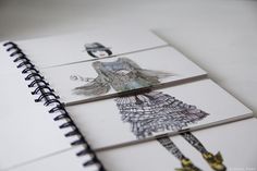 three notebooks with drawings of women on them