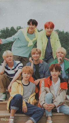 a group of young men sitting next to each other on top of a wooden platform