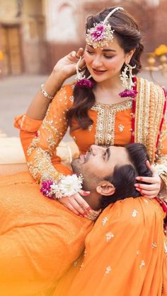 a man is sitting on the back of a woman's head with flowers in her hair