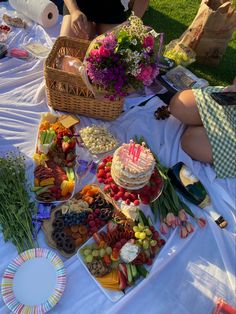 a woman sitting at a table covered in lots of different types of foods and desserts