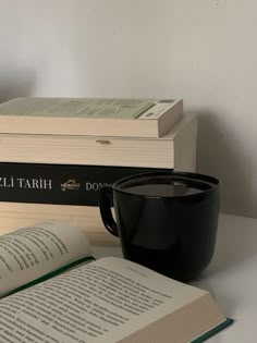 two books and a cup on a table