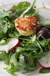 a white plate topped with salad and crab cakes