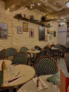 the interior of a restaurant with tables and chairs set up in rows, along with pictures on the wall