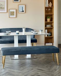 a blue bench sitting in front of a table with plates on it next to a bookshelf