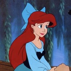 ariel from the little mermaid sitting at a table