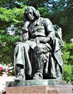 a statue of a man sitting on top of a bench