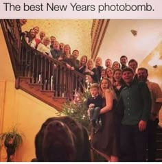 a group of people standing in front of a christmas tree on top of a staircase