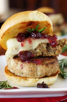 a hamburger with meat, cheese and cranberry sauce