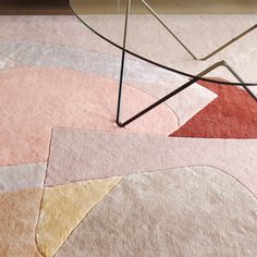 an abstract rug with various colors and shapes on it, including a triangle shaped table