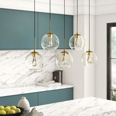 a kitchen with marble counter tops and hanging lights