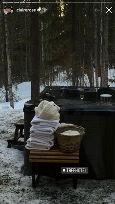 an outdoor hot tub in the snow next to a picnic table with towels on it