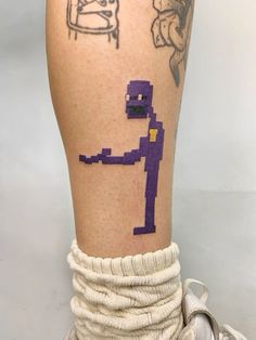 a person's leg with tattoos on it and an image of a cartoon character