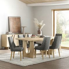 a dining room table with grey chairs around it