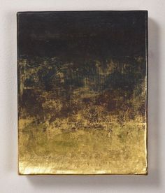 an abstract painting on a white wall with gold and black paint in the center,