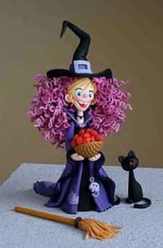 a figurine of a witch with purple hair and a black cat sitting next to it