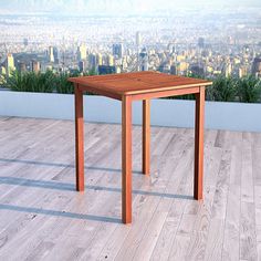 a wooden table sitting on top of a hard wood floor next to a planter