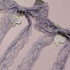 two pieces of lace with butterfly charms on them