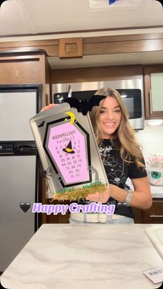 a woman holding up a cake in her kitchen with the words happy birthday written on it