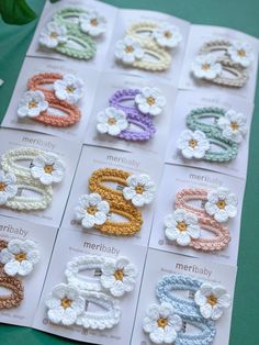 there are many crocheted hair clips on the table with each one's name